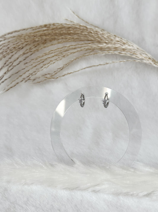 Filigrane silberne Creolen mit funkelnden Zirkonia-Steinen, elegant präsentiert auf hellem Hintergrund mit Pampasgras – zeitloser Everyday-Schmuck – Javi Jewelery