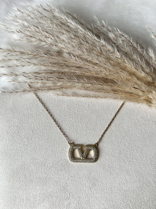 Goldene Halskette mit funkelndem Emblem-Anhänger und fein gesetzten Zirkonia-Steinen – luxuriöser, moderner Schmuck für elegante Looks – Javi Jewelery