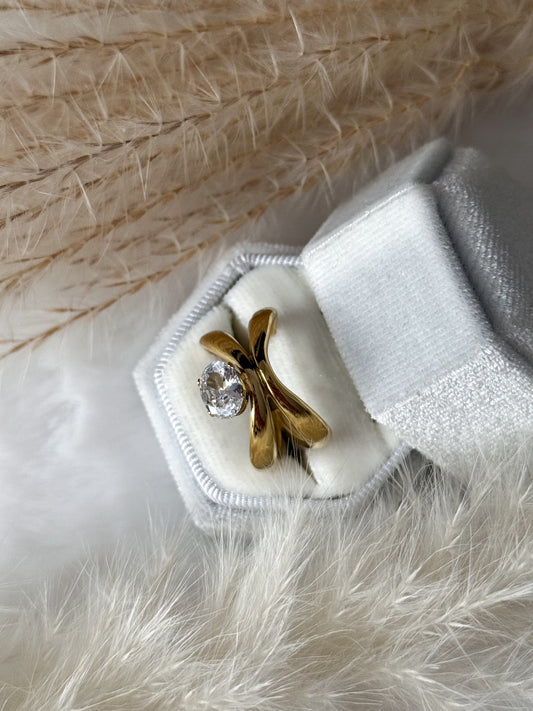 Auffälliger Goldring mit einer dynamischen geschwungenen Fassung, in der ein einzelner klarer Zirkonia (Kristall) sitzt - Javi Jewelery
